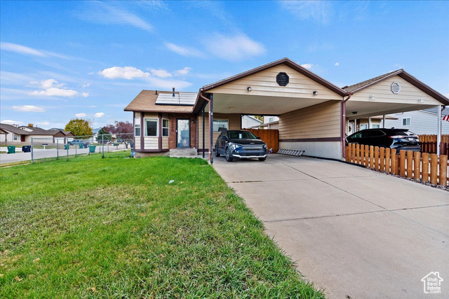 View of front of house with a front lawn and a carport