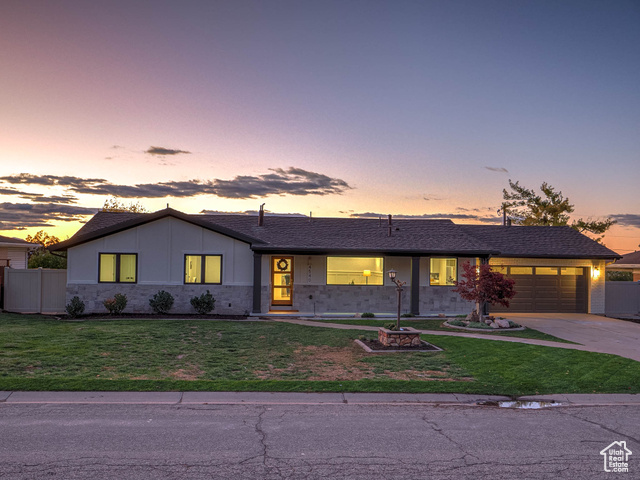 Single story home featuring a garage and a lawn