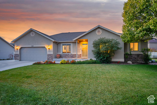 View of front of home with a garage and a lawn