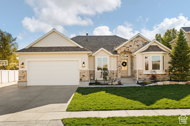 View of front of house featuring a garage and a front yard