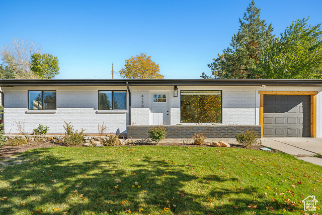 Single story home with a front lawn and a garage