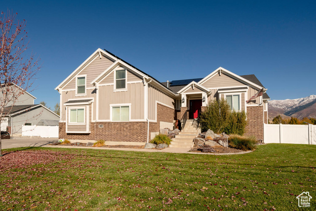 Craftsman-style house featuring a mountain view, a garage, and a front yard