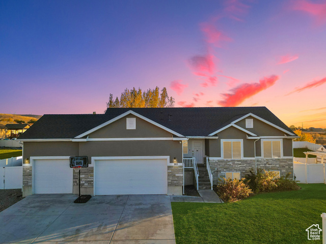 View of front of property featuring a garage and a yard