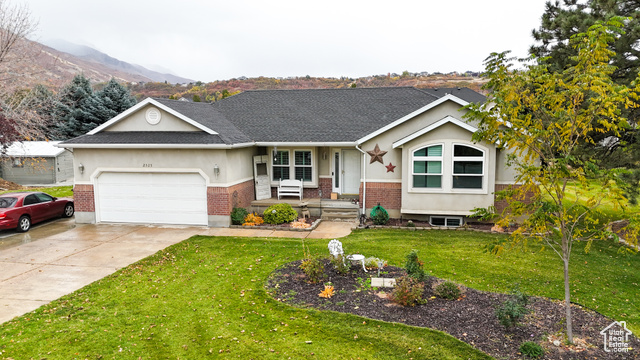 Rambler with front yard, mountain view, and garage