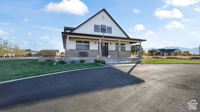 View of front facade with a porch, a front yard, and a mountain view