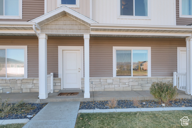 Entrance to property featuring covered porch