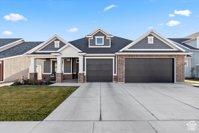 Craftsman inspired home featuring a porch, a garage, and a front lawn