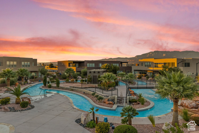 Pool at dusk with a mountain view and a patio area