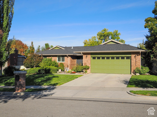 Ranch-style home with a garage and a front yard