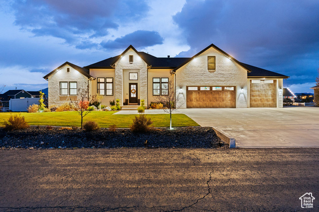 View of front of home with a garage and a lawn