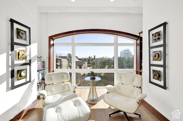 Living area featuring white oak flooring and a large picture window with city views.