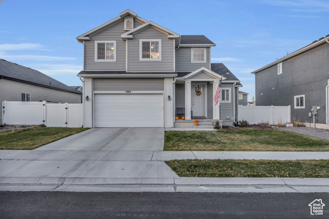 View of front property featuring a front lawn and a garage