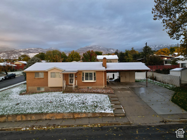 View of front of house with a mountain view and a carport