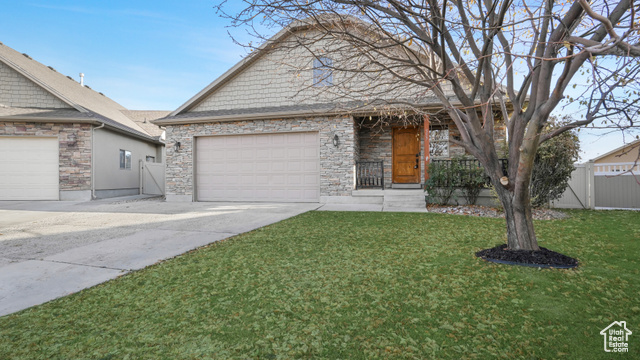 View of front facade featuring a front lawn and a garage