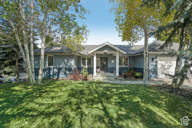 View of front facade featuring a front lawn and a garage