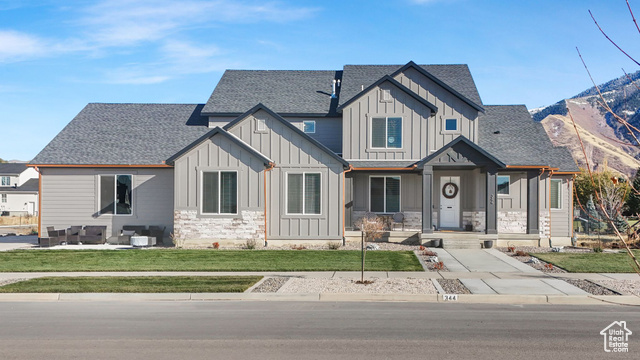 View of front facade with an outdoor living space and a front lawn