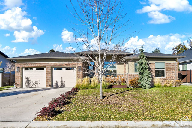 View of front of house featuring a garage and a front lawn