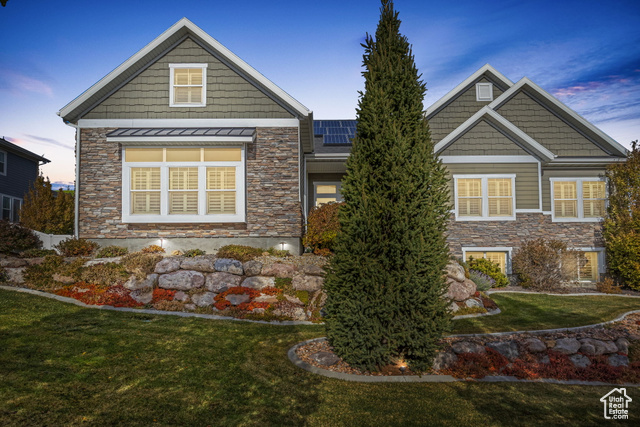 Craftsman house with solar panels and a lawn