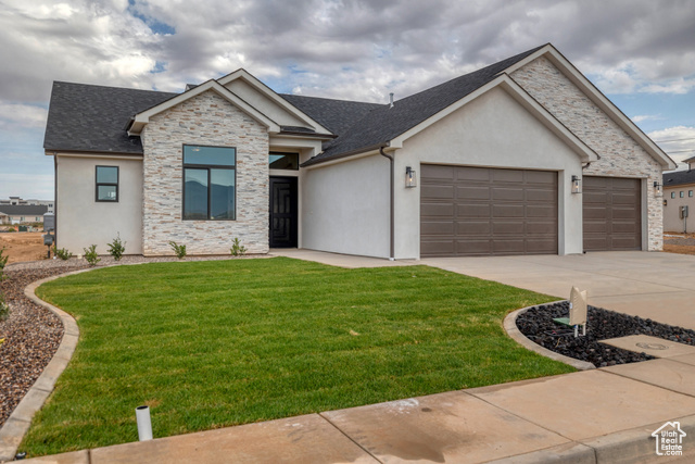 View of front of house with a garage and a front lawn