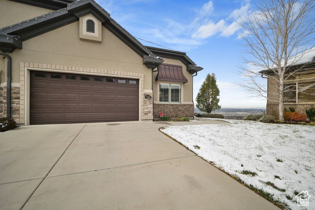 Snow covered property with a garage