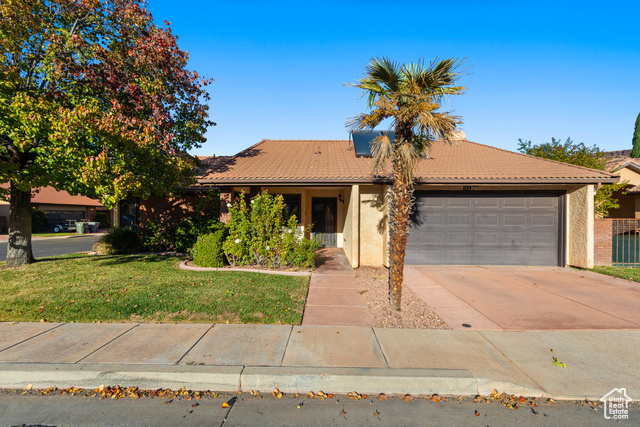 Single story home featuring a front yard and a garage