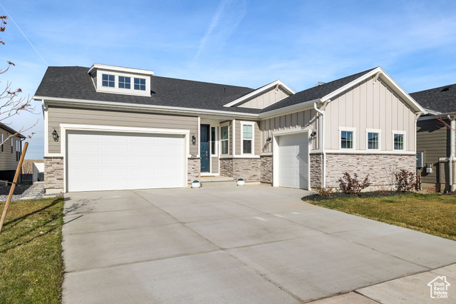 Craftsman-style house featuring a garage and a front lawn