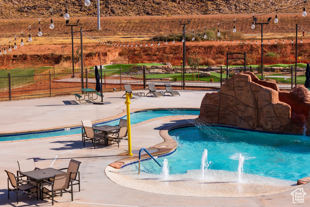 View of swimming pool with pool water feature and a patio