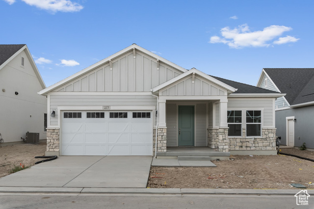 Craftsman inspired home with central AC unit and a garage