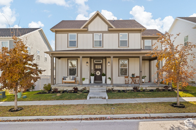 View of front of home featuring central AC, covered porch, and a front lawn