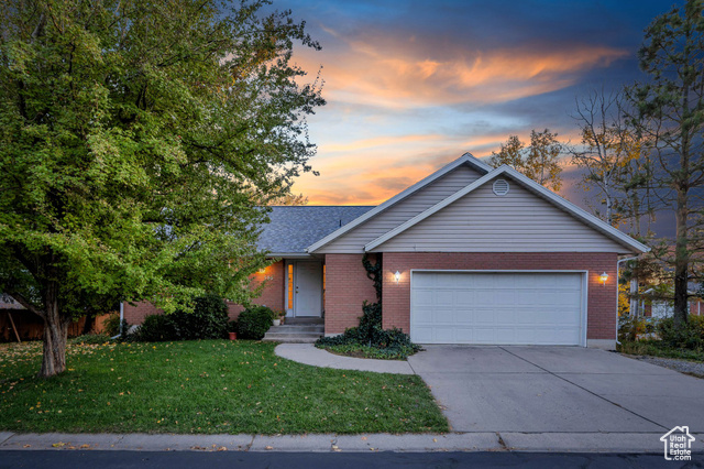 Single story home with a lawn and a garage