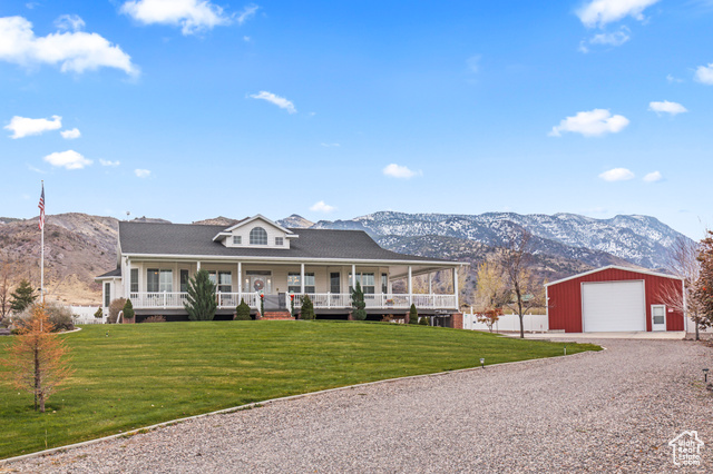 View of front facade with a mountain view, a porch, a garage, and an outdoor structure