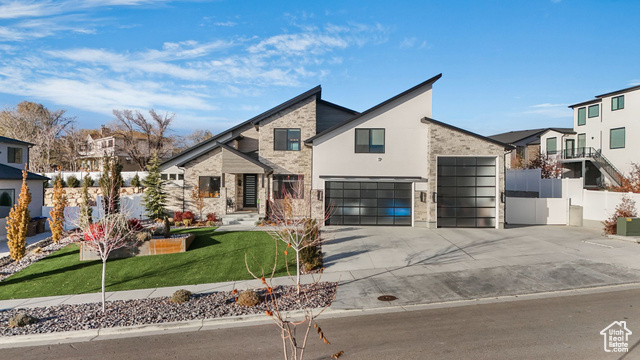 View of front of house featuring a front yard and a garage