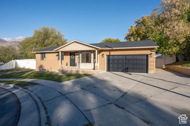 Single story home with a mountain view, a front yard, and a garage