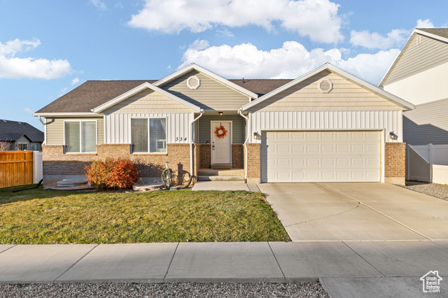 View of front of property with a garage and a front lawn