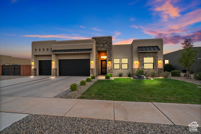 View of front facade with a lawn and a garage