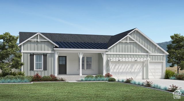 View of front facade with covered porch, a front yard, and a garage