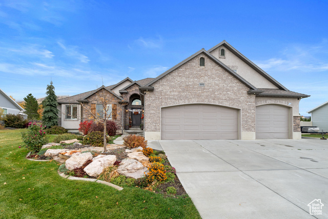 View of front of home with a front lawn and a garage