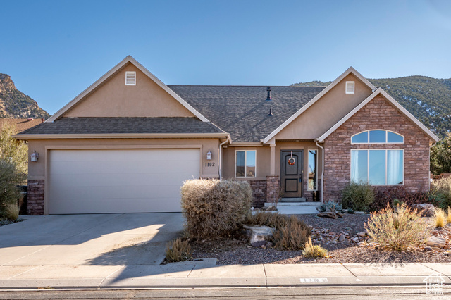 View of front of home with a mountain view and a garage