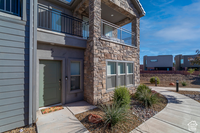 View of exterior entry featuring a balcony