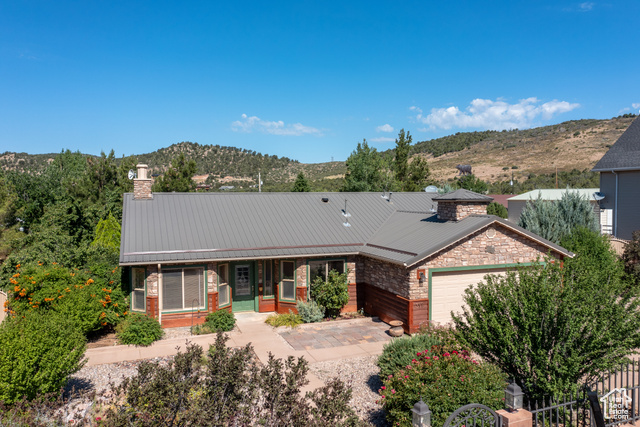 View of front of house with covered porch, a mountain view, and a garage