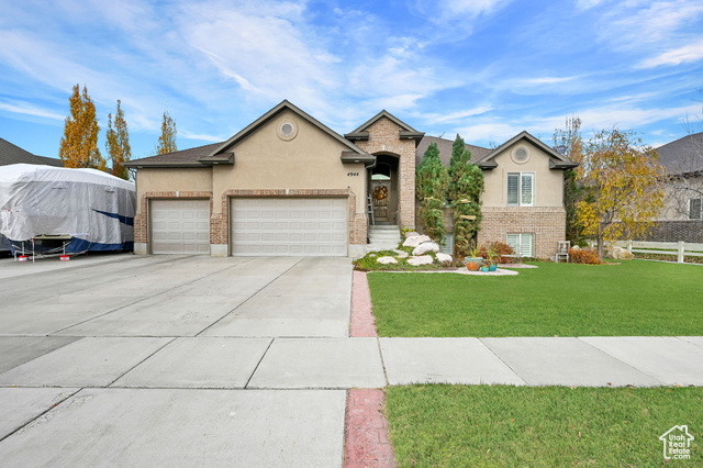 View of front of house featuring a garage and a front lawn