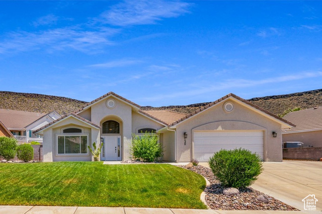 View of front of house featuring a front lawn and a garage