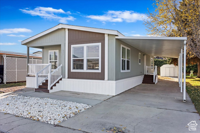 View of front facade with a storage unit and a carport