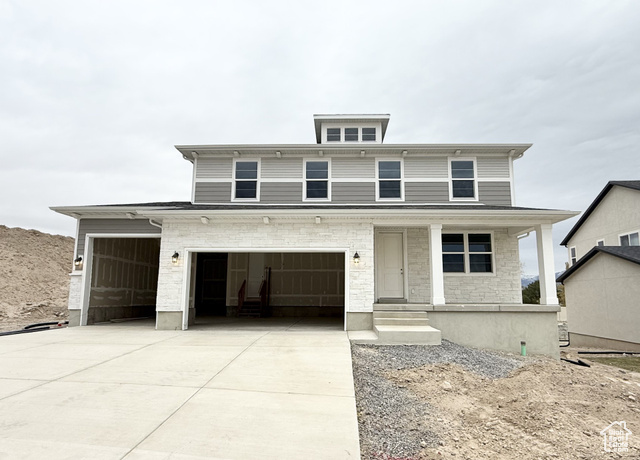 View of front of house featuring covered porch and a garage