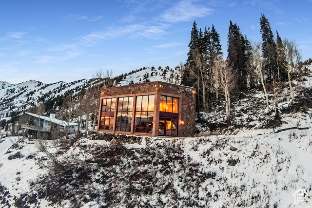 Snow covered back of property featuring a mountain view