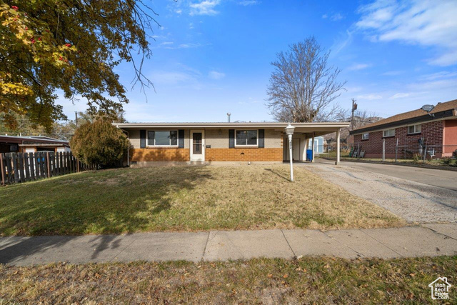 Single story home with a front lawn and a carport