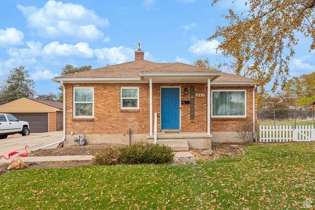 Bungalow featuring a front yard and a garage