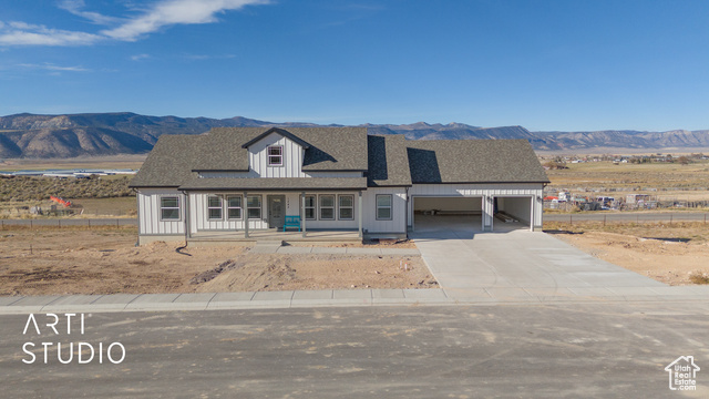 View of front of home with a mountain view, a garage, a carport, and covered porch