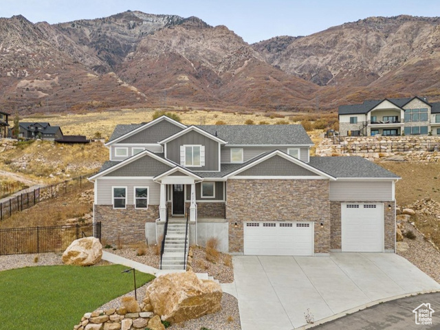 Craftsman-style home with a mountain view, a front yard, and a garage