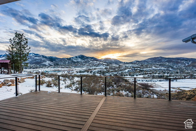 Snow covered deck with a mountain view